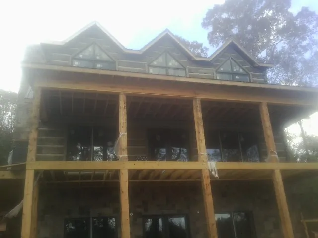 Dormers and porch framing on a large log home under construction — Roof Coating work by our crew in Spring Hill