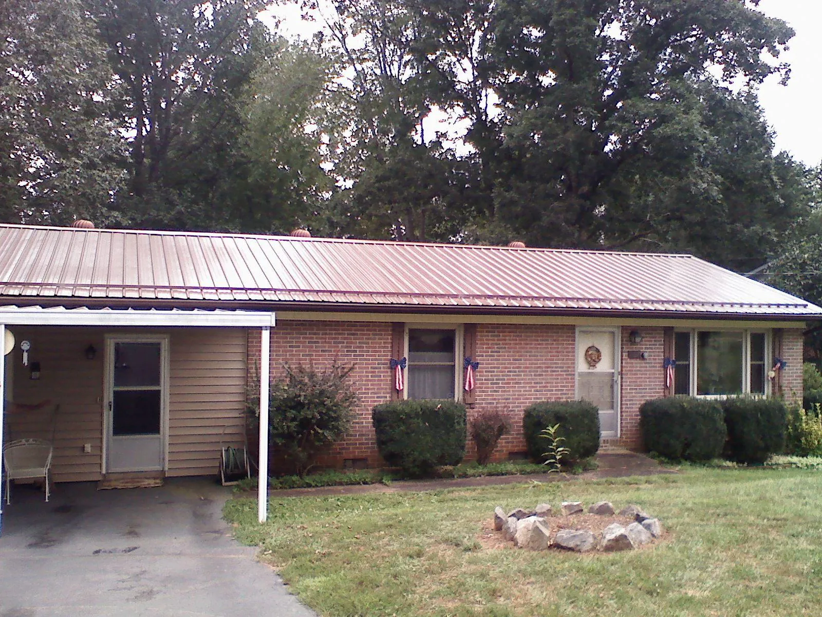 Bronze metal roof and carport on a brick ranch home — Roof Repair work by our crew in Spring Hill